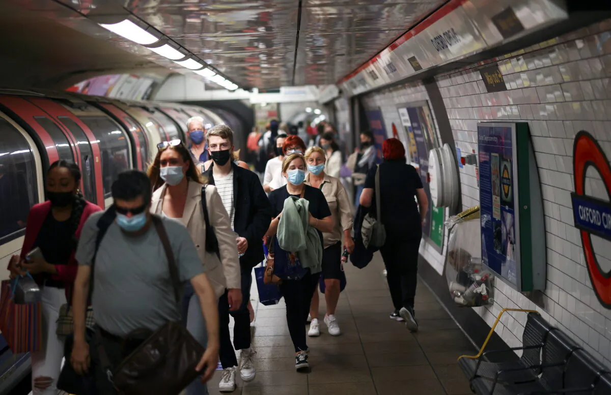 People, some wearing protective face masks, walk along a platform at Oxford Circus underground station, amid the COVID-19 pandemic, in London, on July 4, 2021. (Henry Nicholls/Reuters)