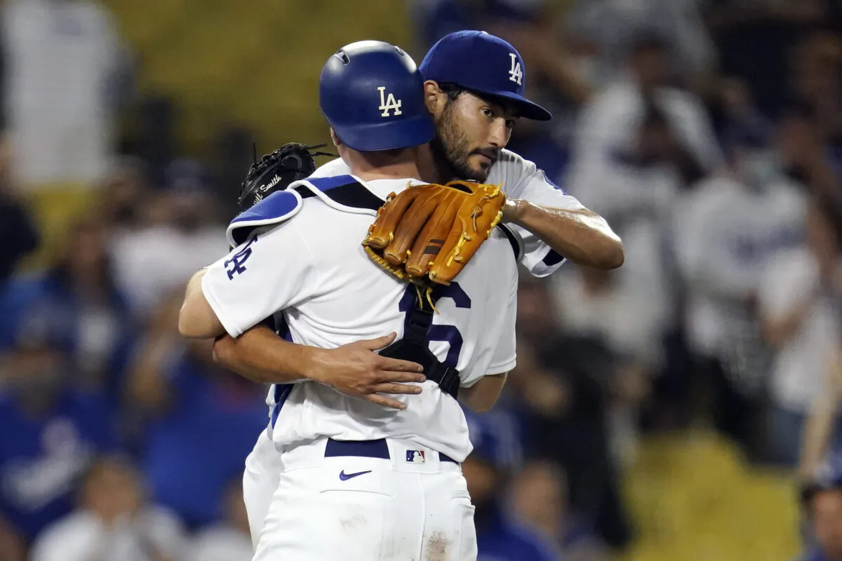 Los Angeles Dodgers relief pitcher Mitch White, right, hugs catcher Will Smith after the team's 9-0 win over the Pittsburgh Pirates in a baseball game in Los Angeles on Aug. 18, 2021. (AP Photo/Marcio Jose Sanchez)