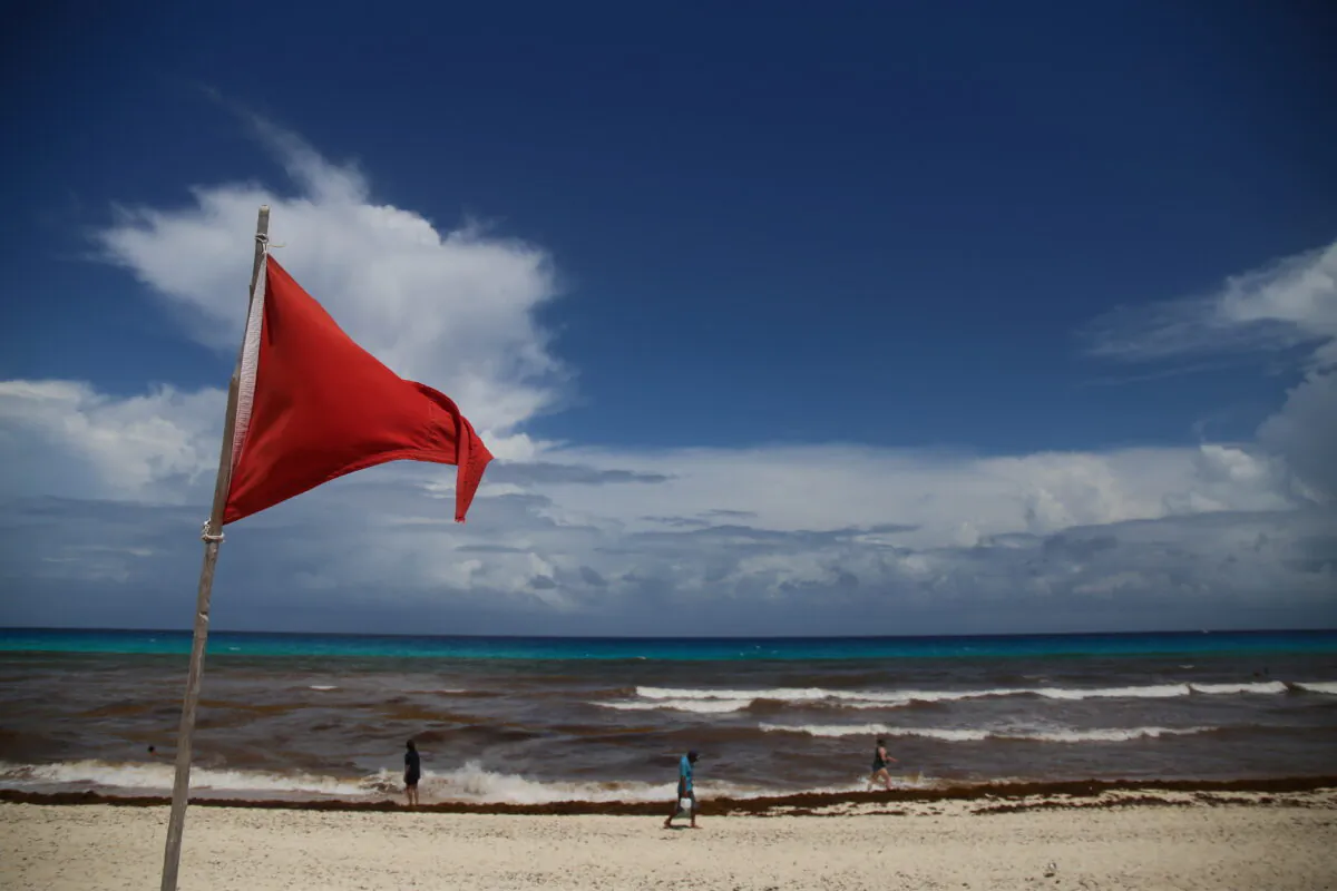 A red flag on the beach warns beachgoers of hazards due to the proximity of Hurricane Grace in Cancun, Mexico, on Aug. 18, 2021. (Paola Chiomante/Reuters)