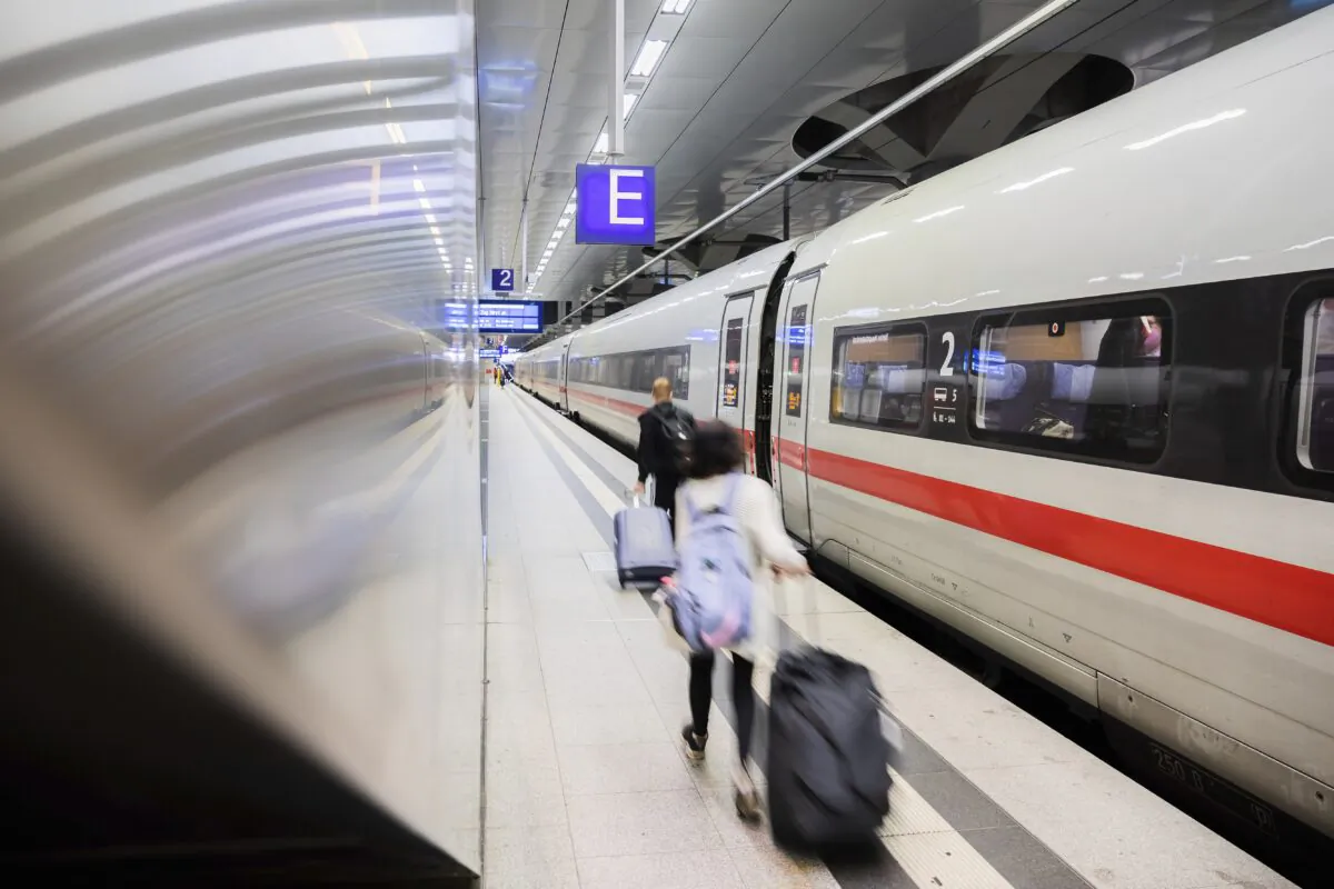 Passengers walk along an ICE train at Berlin Central Station in Berlin, Germany, on Aug. 20, 2021. (Christoph Soeder/dpa via AP)
