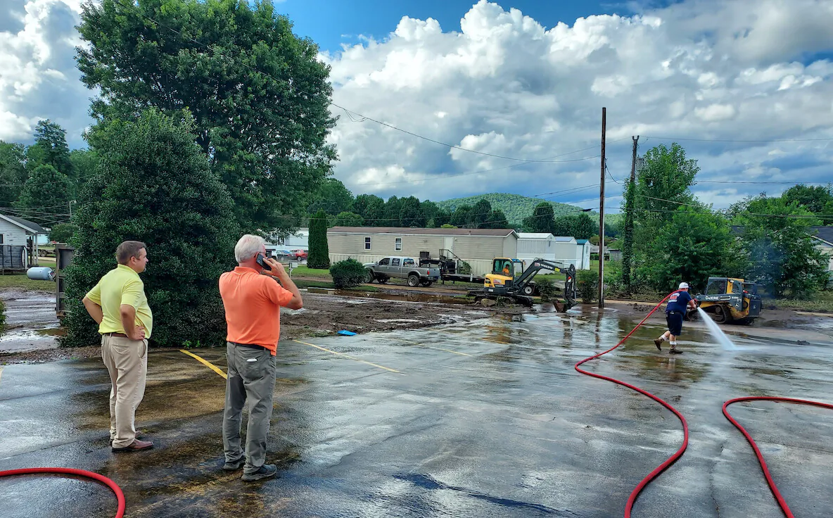 Anchor Baptist Church Pastor Randy Barton and Lowe's Home Improvement Store Manager Brent McCrimmon survey the damage after Tropical Depression Fred flooded the Davidson River Valley in Transylvania County on Aug. 18, 2021. (Matt McGregor/The Epoch Times)