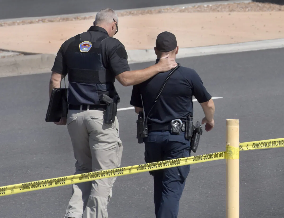 Two officers walk away from the scene after a shootout that left multiple officers injured in northeast Albuquerque, N.M., on Aug. 19, 2021. (Robert Browman/The Albuquerque Journal via AP)