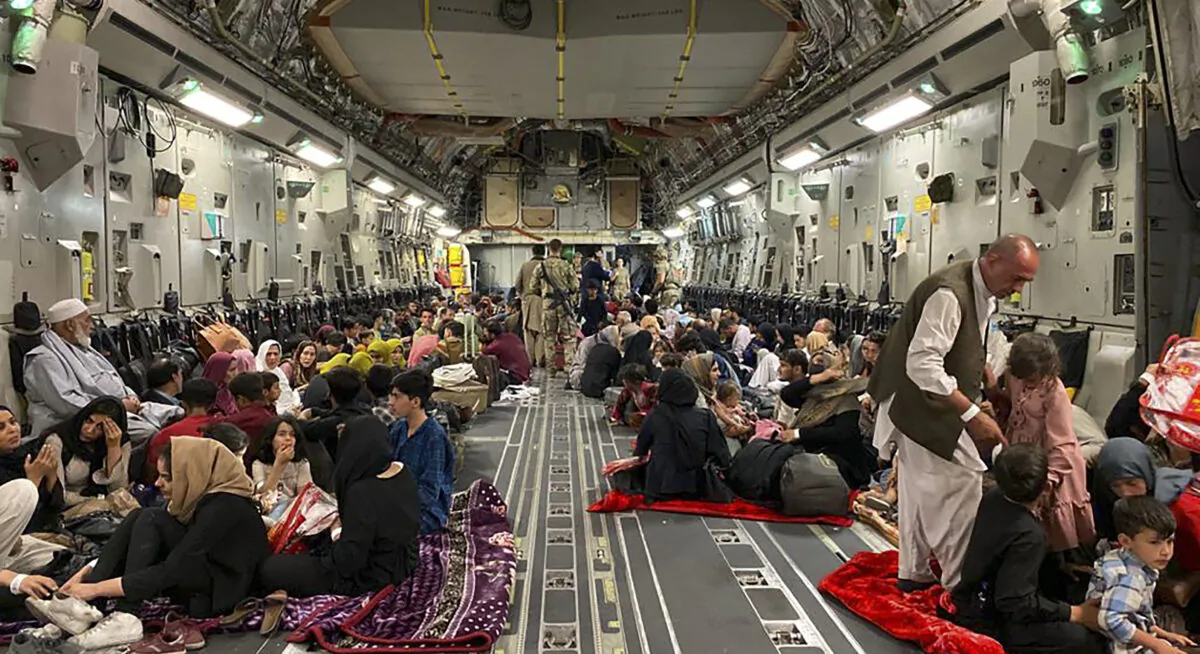 Afghan people sit inside a U.S. military aircraft to leave Afghanistan at the military airport in Kabul on Aug. 19, 2021 after the Taliban's takeover of Afghanistan. (Shakib Rahmani/AFP via Getty Images)