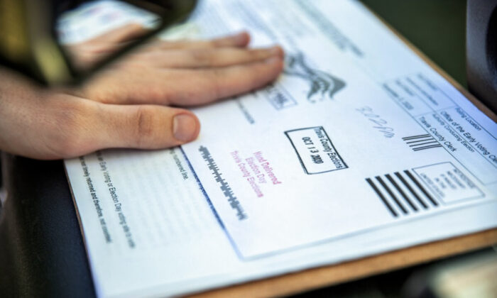 A poll worker stamps a voters ballot before dropping it into a secure box at a ballot drop off location in Austin, Texas on Oct. 13, 2020. (Sergio Flores/Getty Images)