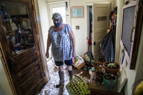 womna-looks-over-damaged-home