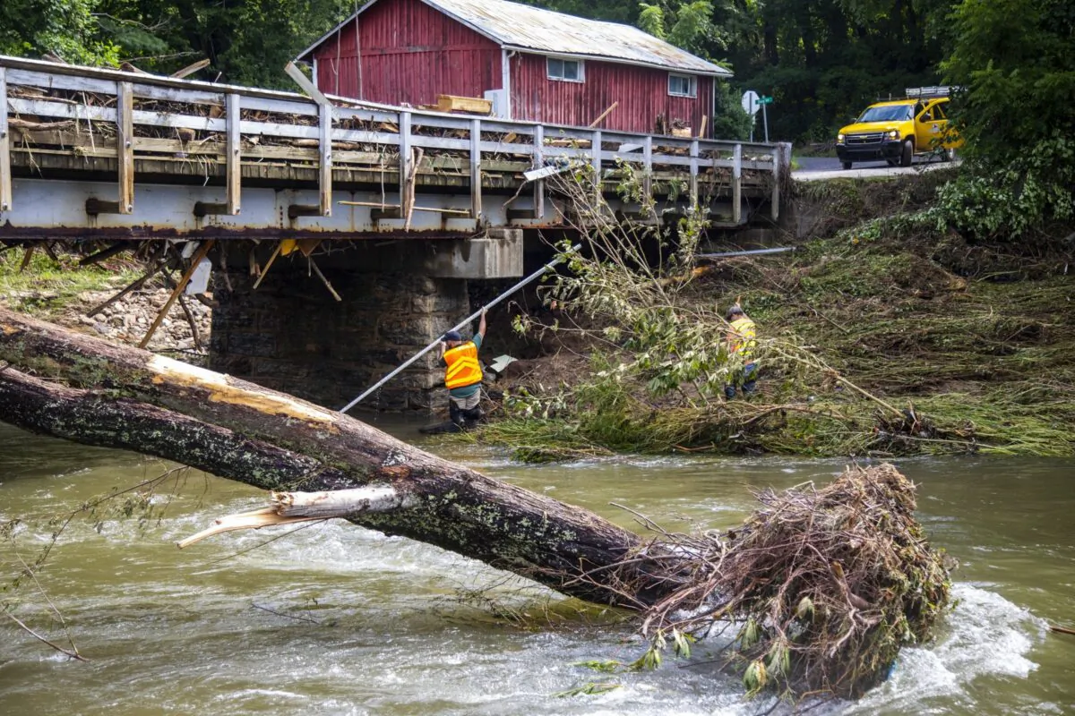 NCDOT workers assess damage to a bridge spanning the Pigeon River, in Bethel, N.C., on Aug. 19, 2021. (Travis Long/The News & Observer via AP)