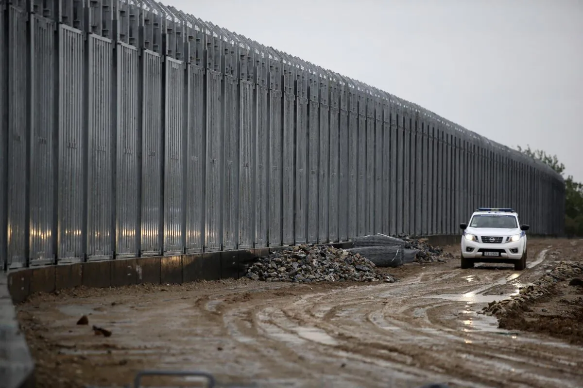 A police car patrols alongside a steel wall at Evros river, near the village of Poros, at the Greek-Turkish border, Greece on May 21, 2021. (Giannis Papanikos/AP Photo)