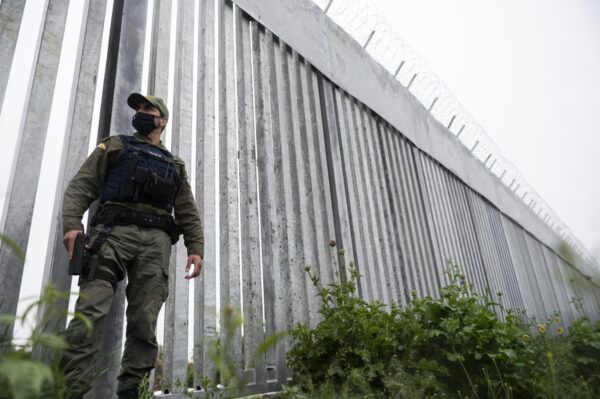 A policeman patrols alongside a steel border wall at Evros river, near the village of Poros, at the Greek-Turkish border on May 21, 2021. (Giannis Papanikos/AP Photo)