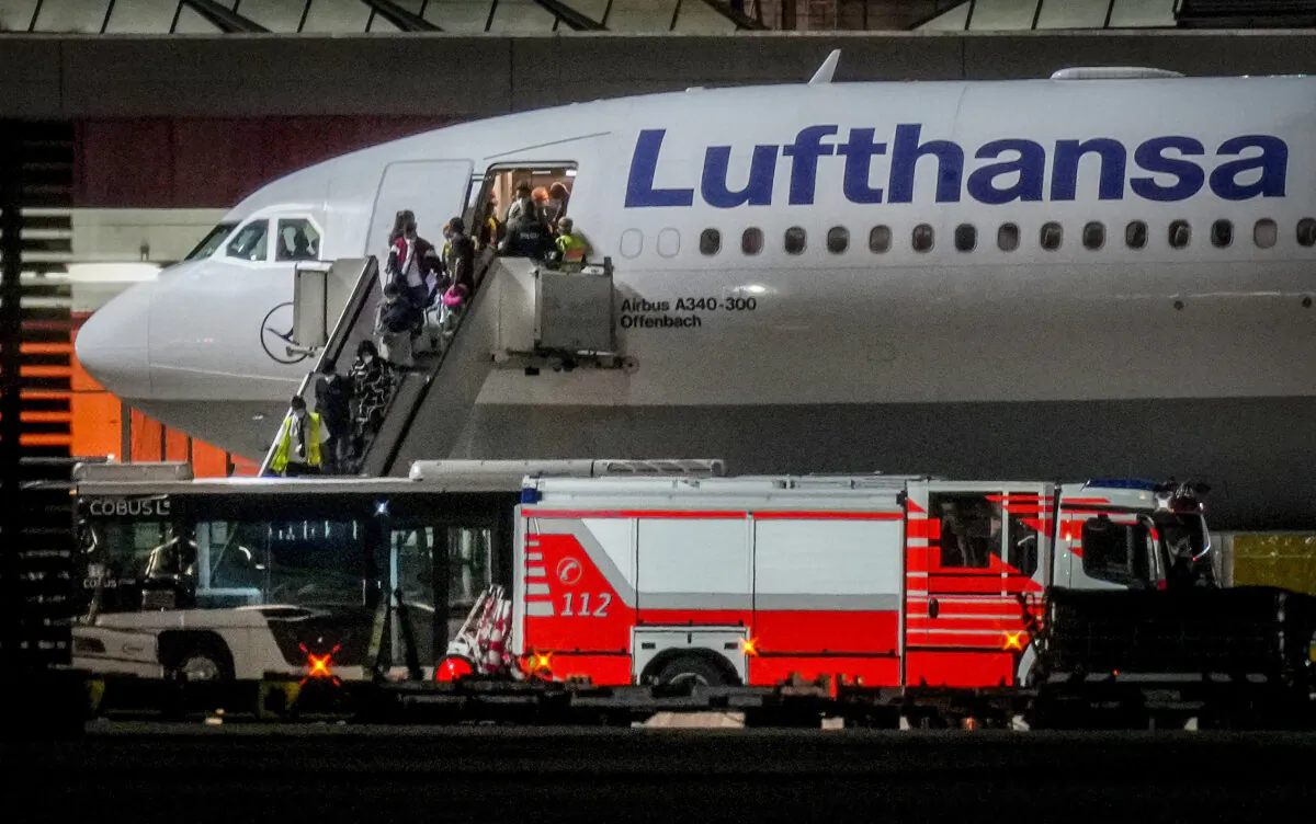 People disembark from a Lufthansa aircraft coming from Tashkent in Uzbekistan that landed at the airport in Frankfurt, Germany, on Aug. 18, 2021. (Michael Probst /AP Photo)
