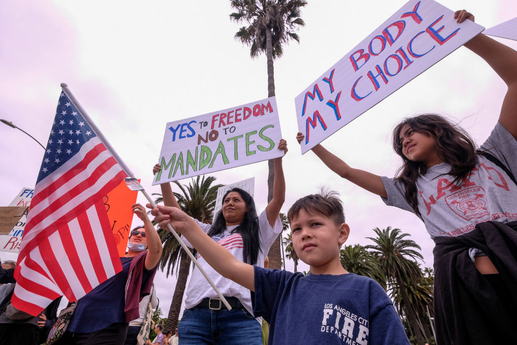 Protesters hold signs as they demonstrate during a "No Vaccine Passport Rally," in Santa Monica, Calif., on August 21, 2021. (Ringo Chiu/AFP via Getty Images)