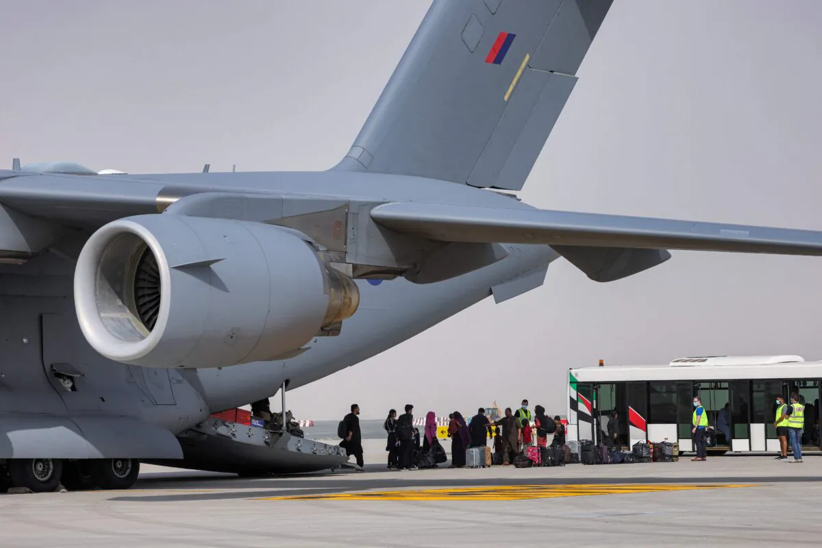 People disembark off a Royal Air Force Boeing C-17A Globemaster III military transport aircraft carrying evacuees from Afghanistan and arriving at Al-Maktoum International Airport in the United Arab Emirates on Aug. 19, 2021. (Giuseppe Cacace /AFP via Getty Images)