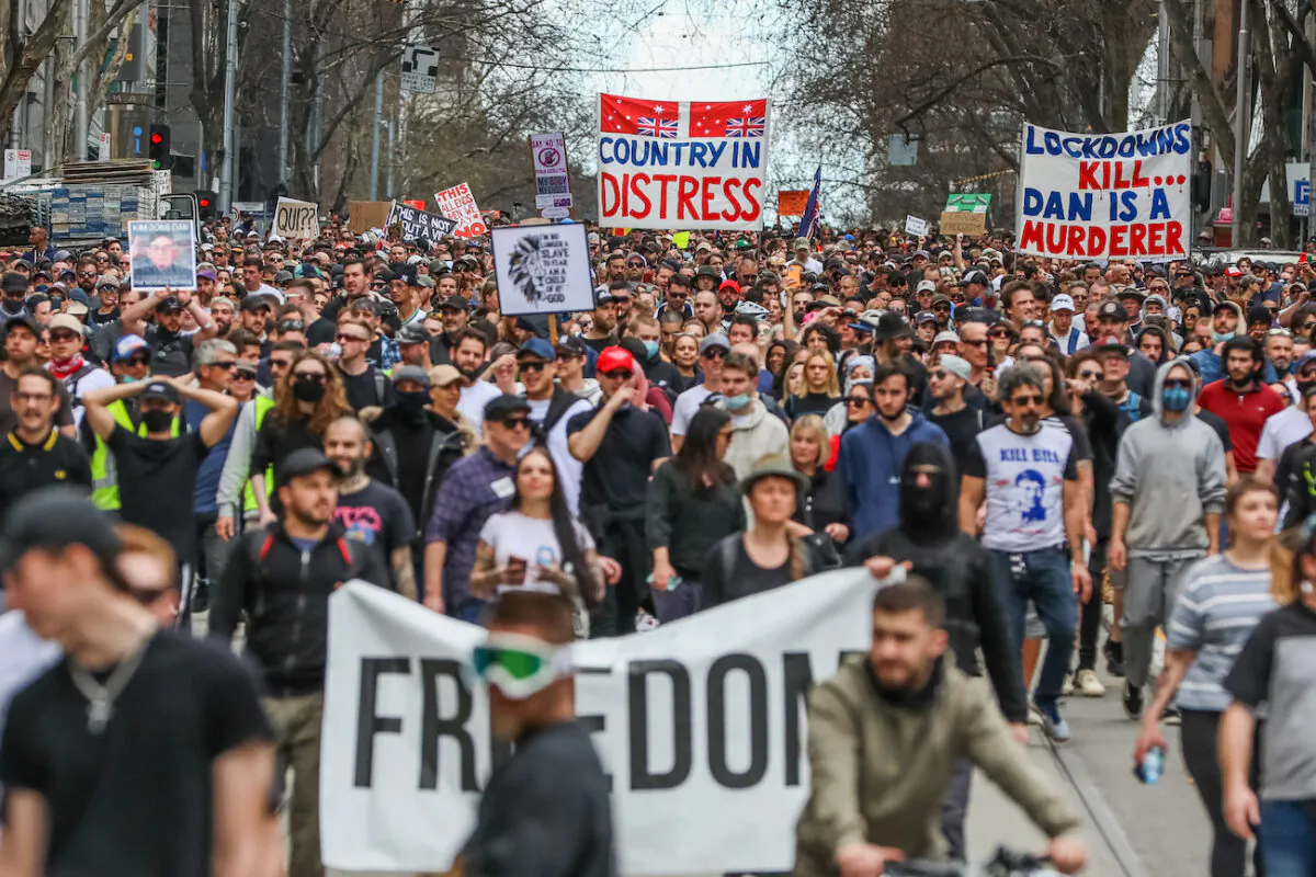 Protesters are seen marching holding banners in Melbourne, Australia, on on Aug, 21, 2021. (Getty Images)