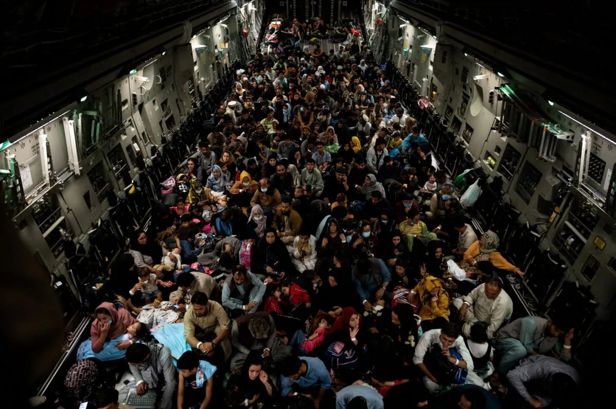 Evacuees from Afghanistan sit inside a military aircraft during an evacuation from Kabul, in this photo taken on Aug. 19, 2021 at undisclosed location and released on Aug. 20, 2021. (Staff Sgt. Brandon Cribelar/U.S. Marine Corps/Handout via Reuters)