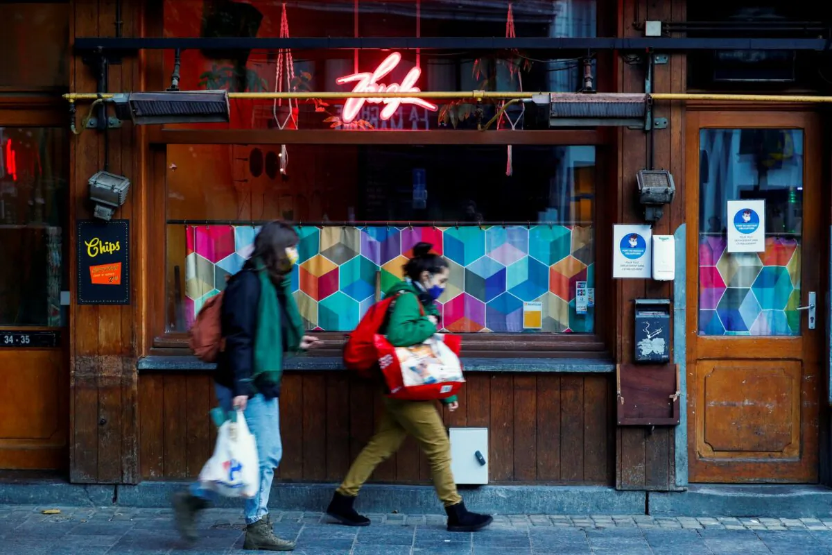 People walk past a closed restaurant, as restaurants were forced to close for four weeks, after a Belgian federal government decision in order to tackle a surging second wave of the coronavirus disease in the country, in Brussels, Belgium, on Oct. 19, 2020. (Francois Lenoir/Reuters)