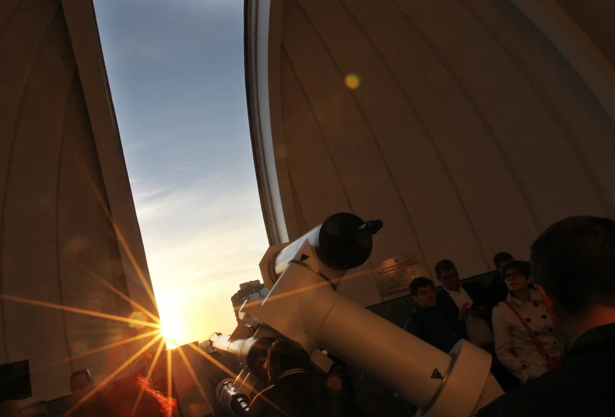 A file photo of people using a telescope. (Alexander Klein/AFP/GettyImages)
