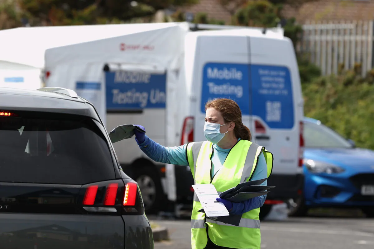 Members of the Health and Social Care team collect completed COVID-19 tests during CCP virus surge testing at Kilkeel Leisure Centre in Northern Ireland on June 7, 2021. (Liam McBurney/PA)