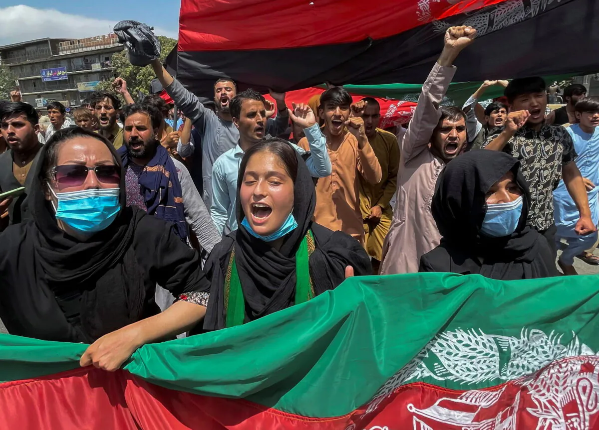 People carry the national flag at a protest held during the Afghan Independence Day in Kabul, Afghanistan, on Aug. 19, 2021. (Stringer/Reuters)
