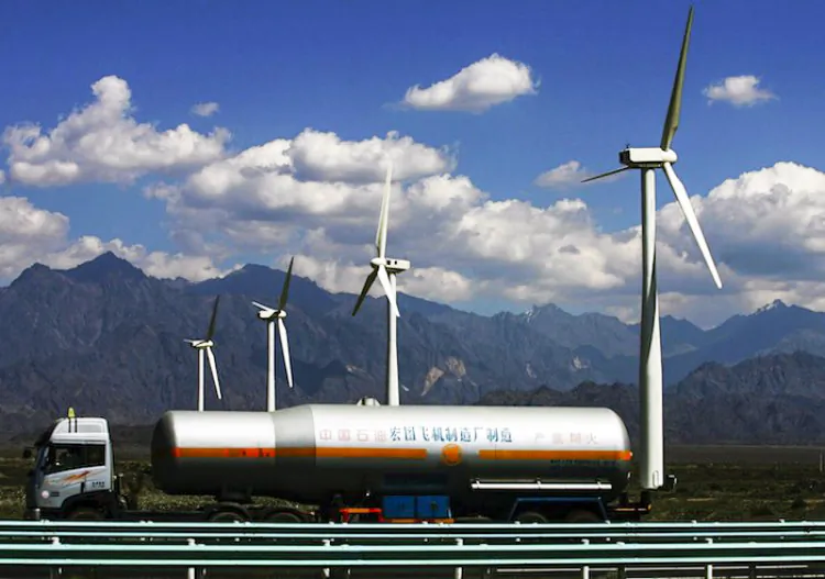 An oil truck driving past wind turbines at the Dafancheng Wind Power Plant, the largest of its kind in Aisa, in 2007 in Dafancheng of Xinjiang Uygur Autonomous Region, China. (China Photos/Getty Images)