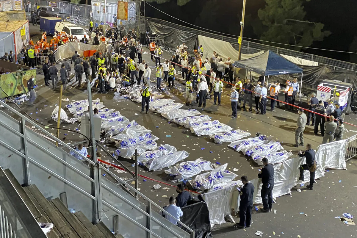 Israeli security officials and rescuers stand around the bodies of victims who died during Lag Baomer celebrations at Mt. Meron in northern Israel, on April 30, 2021. (Ishay Jerusalemite/Behadrei Haredim via AP)