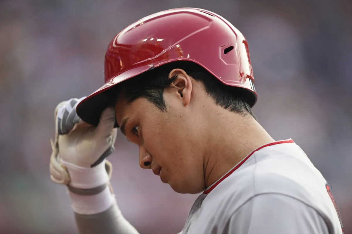 Los Angeles Angels' Shohei Ohtani takes off his helmet as he walks back to the dugout after grounding out during the ninth inning of the team's baseball game against the Cleveland Indians in Cleveland on Aug. 21, 2021. The Indians won 5-1. (AP Photo/Tony Dejak)