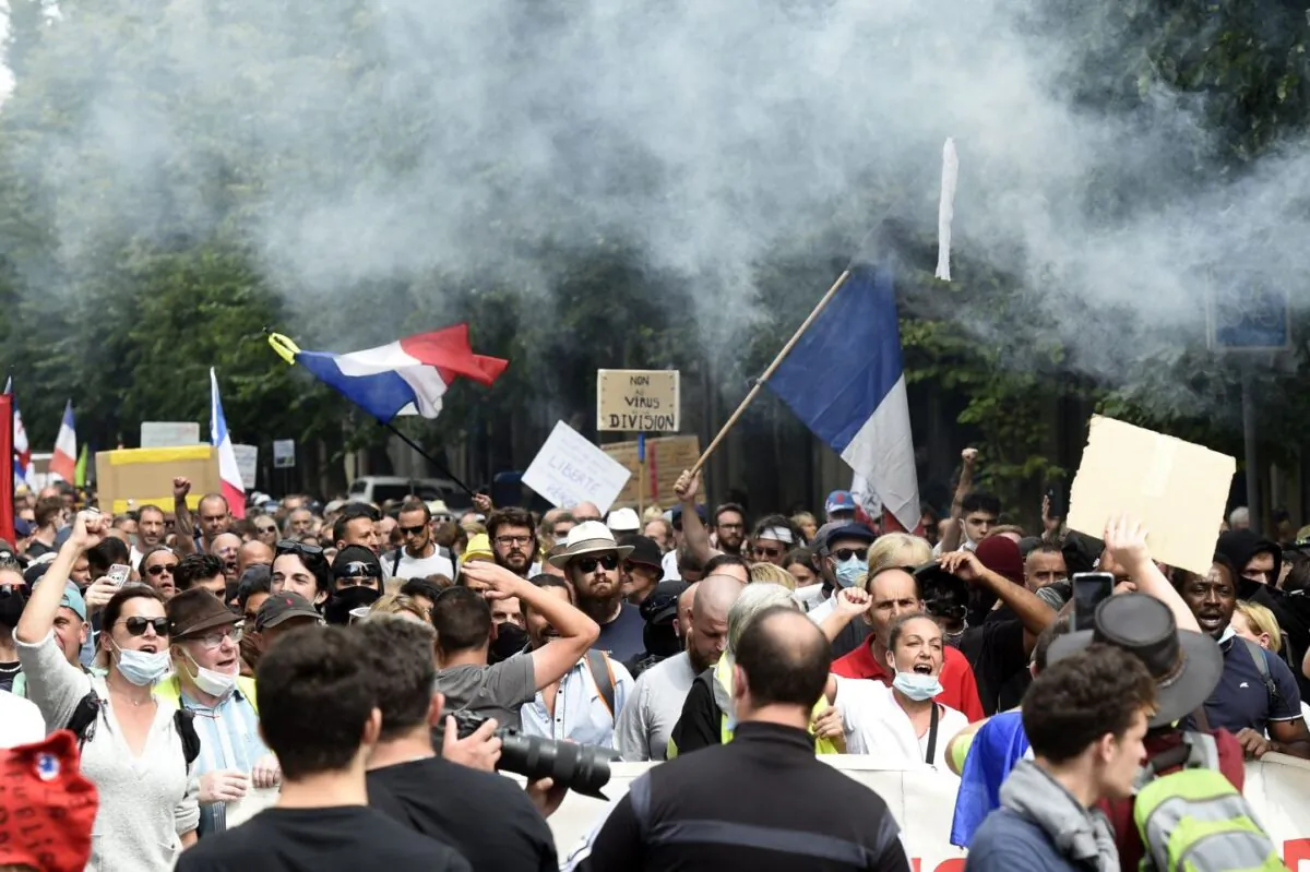 Protesters shout and wave flags during a national day of protest against the compulsory COVID-19 vaccination for certain workers and the mandatory use of the health pass called for by the French government in Lille, northern France, on Aug. 21, 2021. (Francois Lo Presti/AFP via Getty Images)