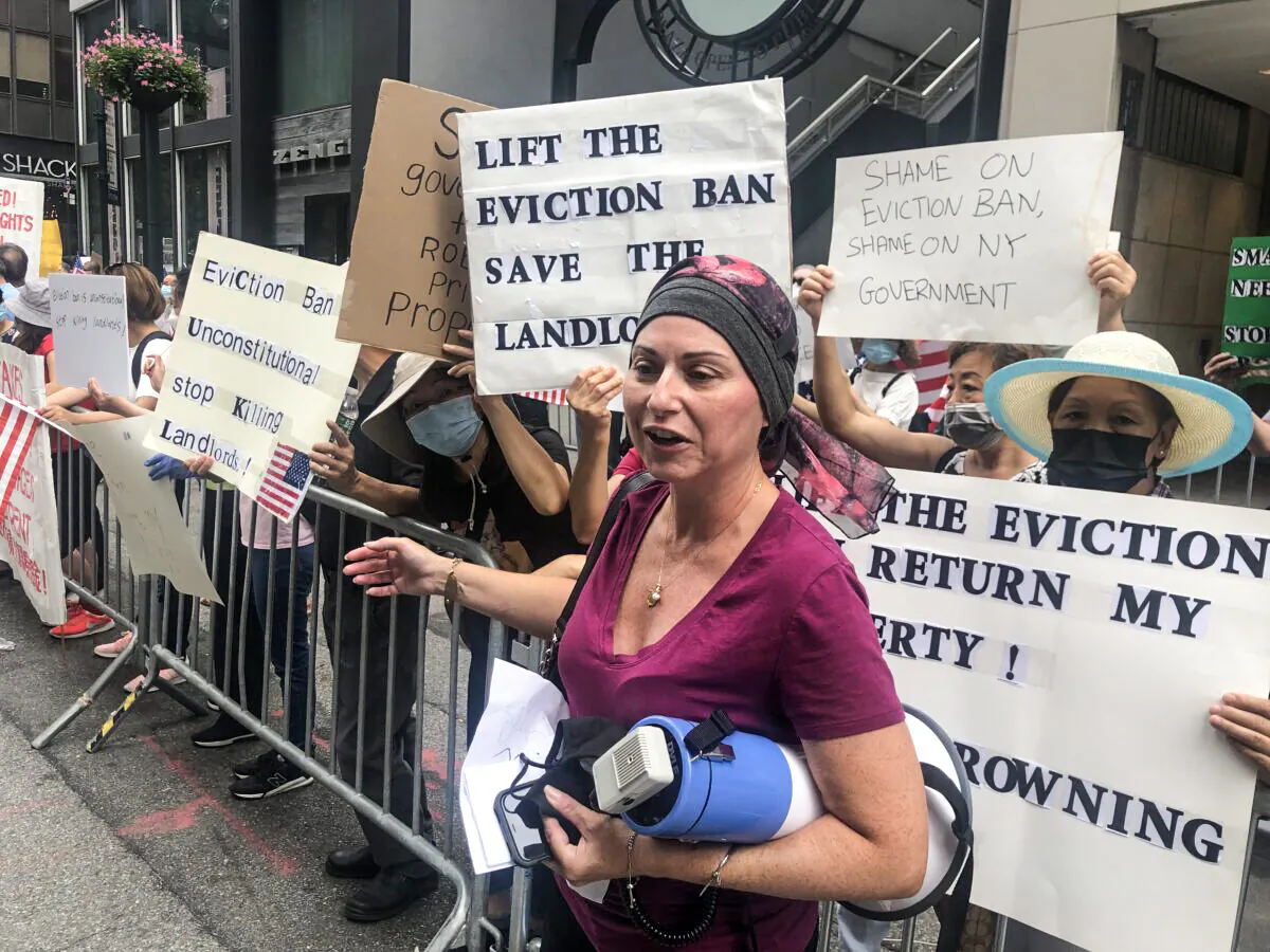 Landlord and cancer sufferer Rosanna Morey holds a megaphone while protesting in front of the New York Governor's office on Aug. 20, 2021. (Enrico Trigoso/The Epoch Times)