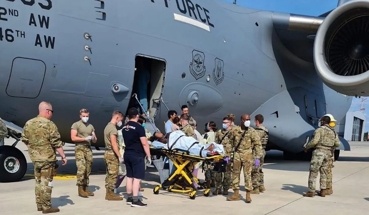 Medical support personnel help an Afghan mother and family off a U.S. Air Force C-17, moments after she delivered a child aboard the aircraft upon landing at Ramstein Air Base, Germany, on Aug. 21, 2021. (U.S. Air Mobility Command via Reuters)