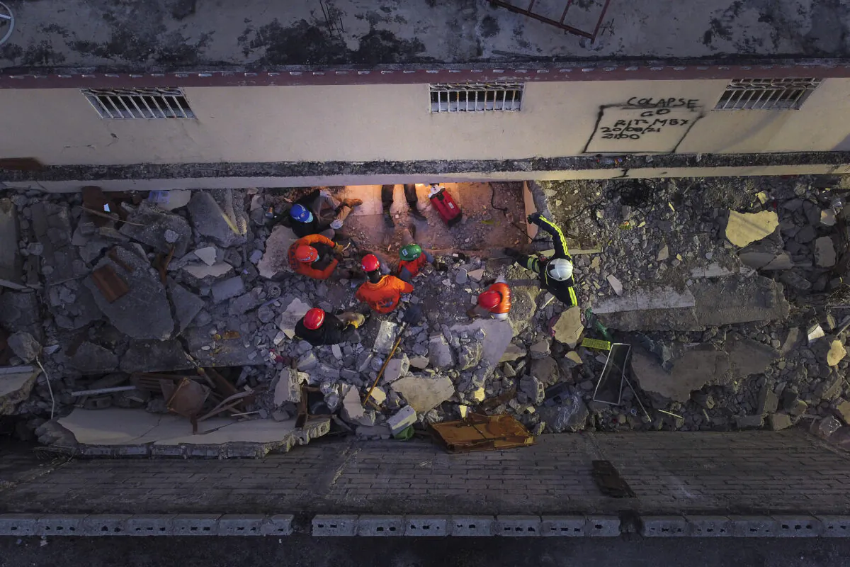 Mexican firefighters work in the early morning hours in a search and rescue mission, amid the rubble from last week's 7.2 magnitude earthquake, in Les Cayes, Haiti, on Aug. 21, 2021. (Matias Delacroix/AP Photo)