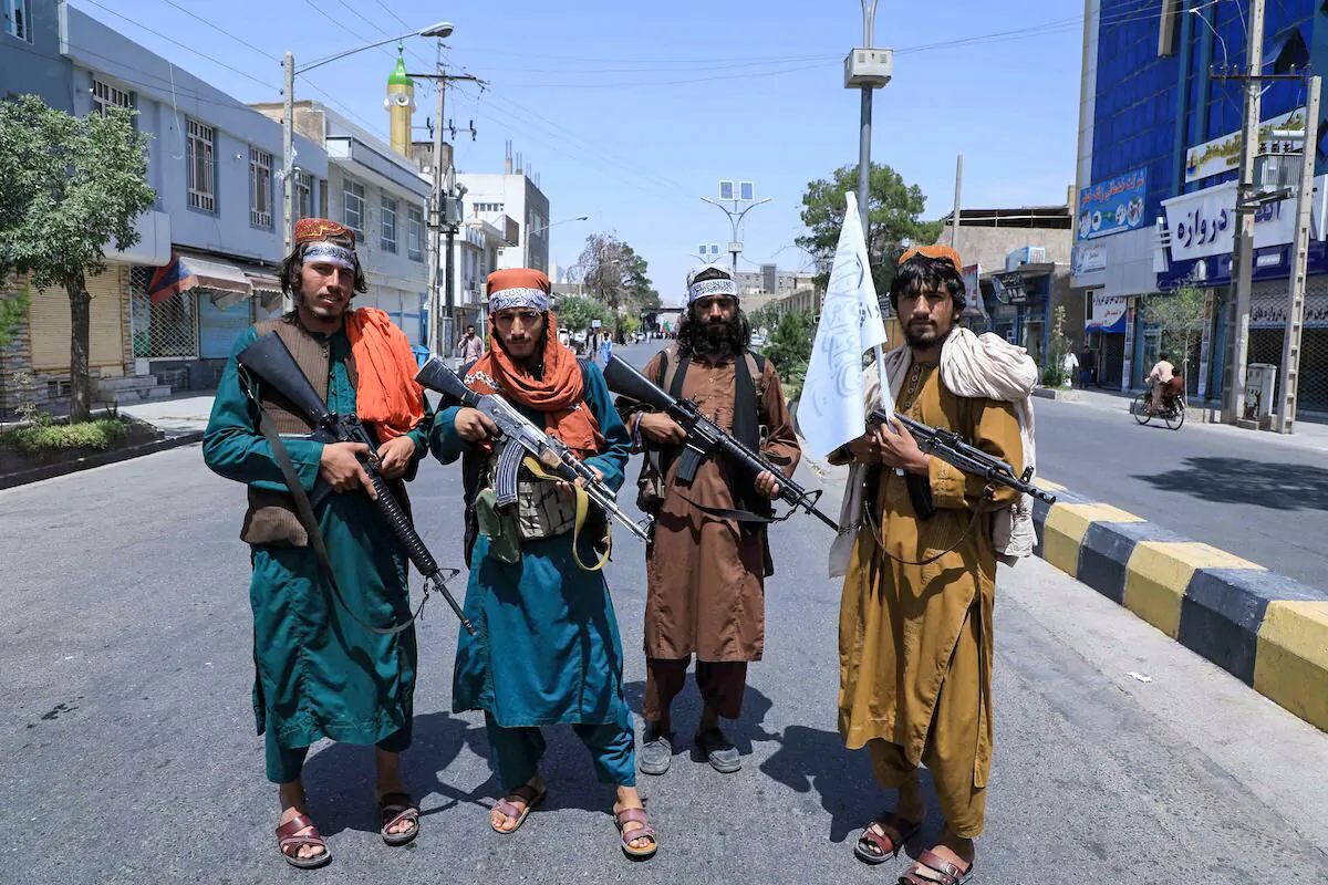 Taliban fighters stand guard along a road near the site of an Ashura procession which is held to mark the death of Imam Hussein, the grandson of Prophet Mohammad, along a road in Herat on Aug. 19, 2021, amid the Taliban's military takeover of Afghanistan. (Aref Karimi/AFP via Getty Images)
