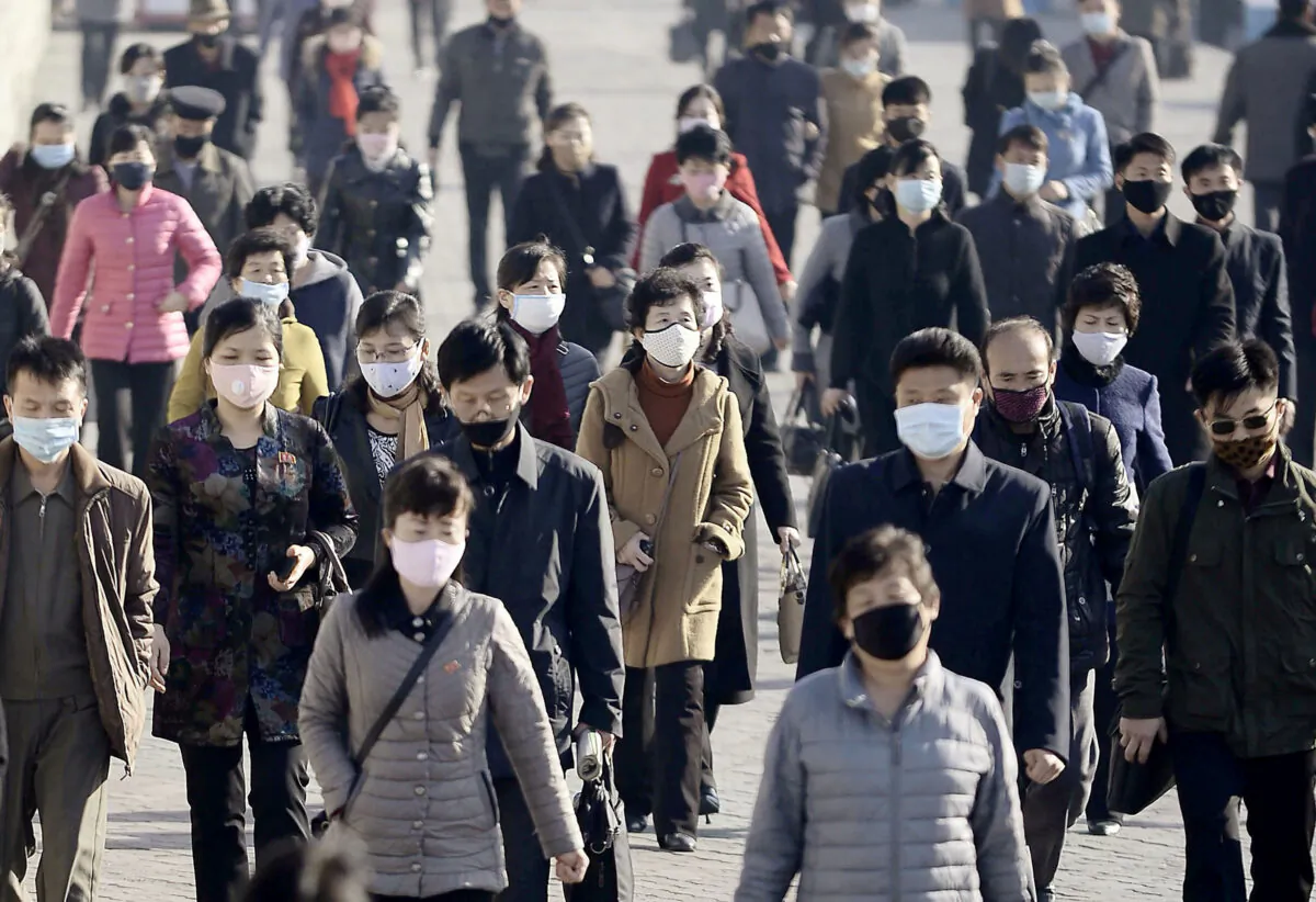 People wearing protective face masks commute amid concerns over COVID-19 in Pyongyang, North Korea on March 30, 2020. (Credit Kyodo/via Reuters)
