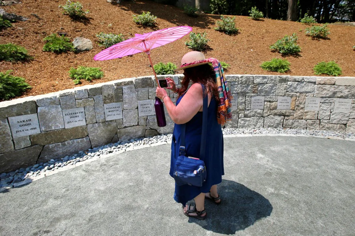 Karla Hailer, a fifth-grade teacher, shoots a video where a memorial stands at the site where five women were hanged as witches more than 325 years ago, in Salem, Mass., on July 19, 2017. (Stephan Savoia/AP Photo)