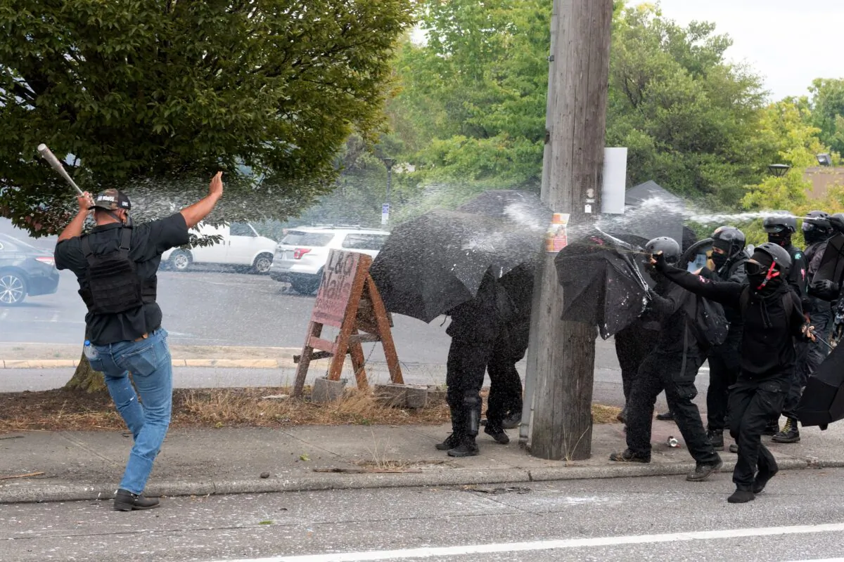 Antifa members (R) attack a Proud Boys member in Portland, Ore., on Aug. 22, 2021. (Mathieu Lewis-Rolland/AFP via Getty Images)