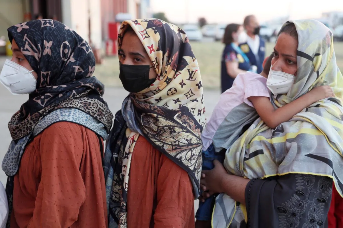 Afghan women queue upon their arrival aboard a second evacuation airplane, carrying Afghan collaborators and their families, that landed at the Torrejon de Ardoz air base, 30 km (18.6 miles) away from Madrid on Aug. 20, 2021. (Mariscal/ POOL/ AFP via Getty Images)