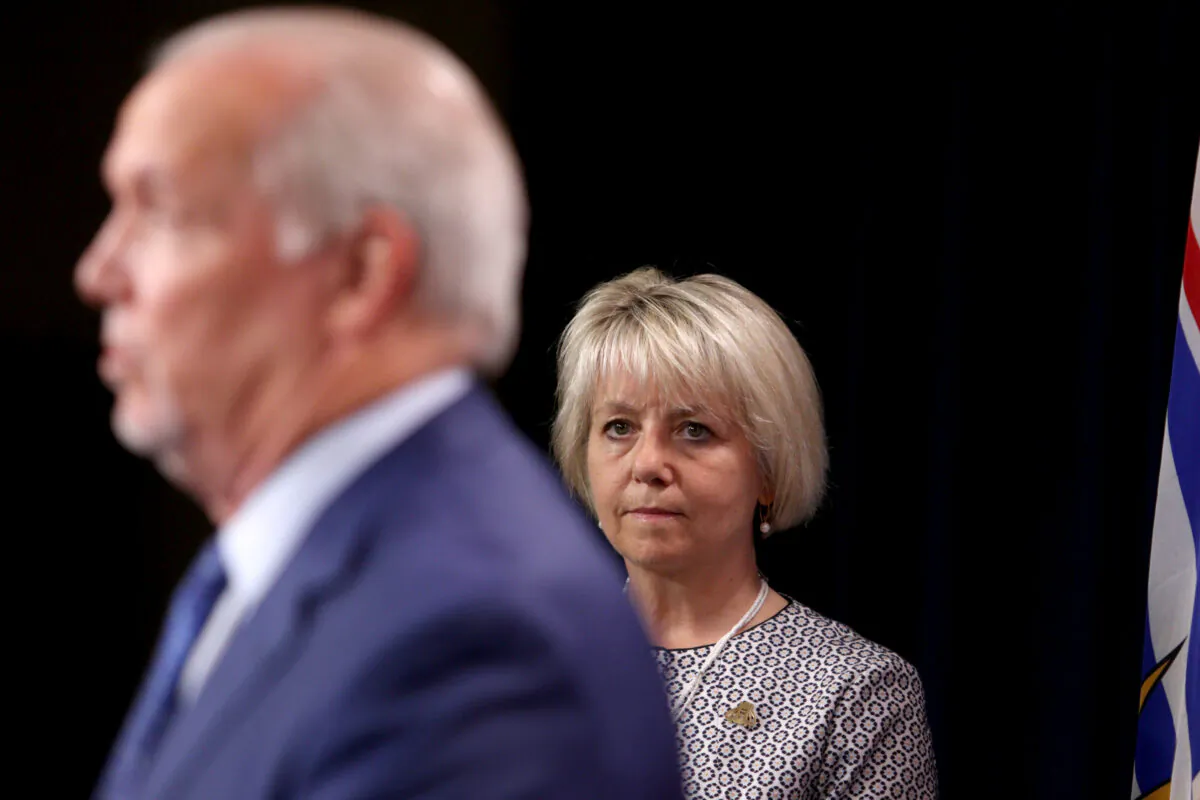 B.C. Provincial Health Officer Dr. Bonnie Henry looks on as Premier John Horgan speaks about the COVID-19 vaccine card set to arrive Sept. 13, during a press conference at the provincial legislature in Victoria on Aug. 23, 2021. (The Canadian Press/Chad Hipolito)