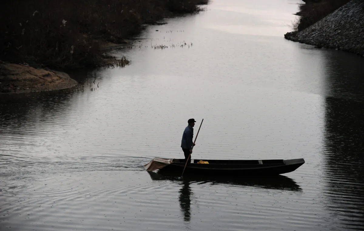 A Chinese fisherman sails on a tributary of the Yalu River between North Korea and China on Nov. 24, 2010. (Frederic J. Brown/AFP via Getty Images)