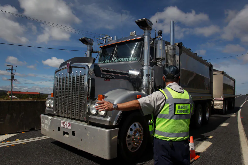 A Queensland Transport Inspector signals to a truck driver at the Queensland border in Wallangarra, Australia, on April 2, 2020. (Lisa Maree Williams/Getty Images)