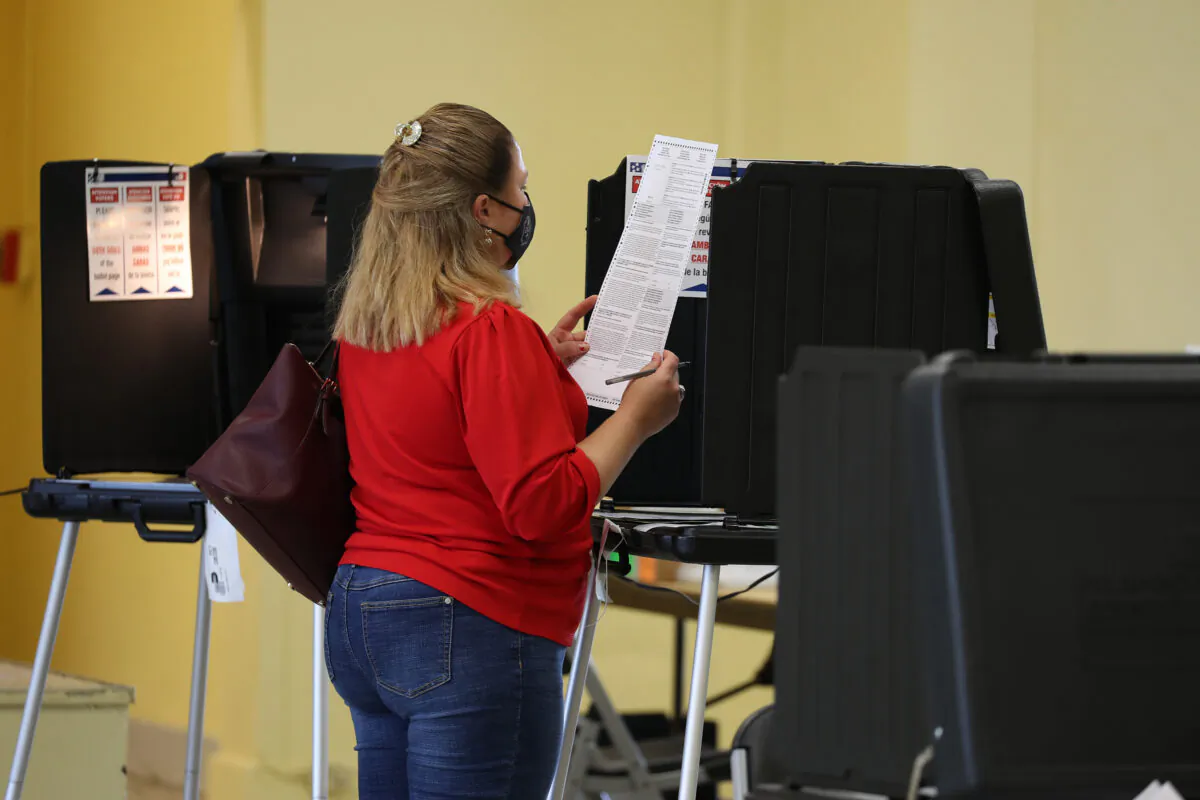 A voter reads her ballot while voting at the Legion Park polling place in Miami on Nov, 3, 2020.  (Joe Raedle/Getty Images)