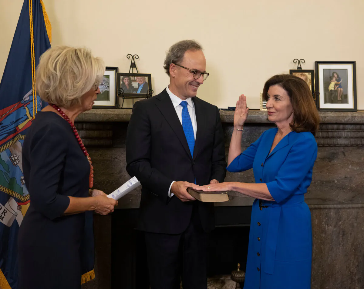 Kathy Hochul (R) is sworn-in as New York State's 57th Governor by Chief Judge Janet DiFiore (L) while First Gentleman Bill Hochul (C) holds the Bible, at the New York State Capitol, in New York, on Aug. 24. (Mike Groll/Office of Governor Kathy Hochul)