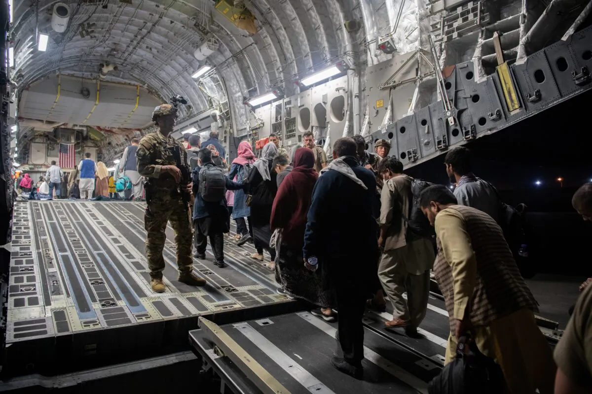 Afghans board a U.S. Air Force C-17 Globemaster III transport plane during an evacuation at Hamid Karzai International Airport in Kabul, Afghanistan, on Aug. 22, 2021. (U.S. Air Force via Reuters)