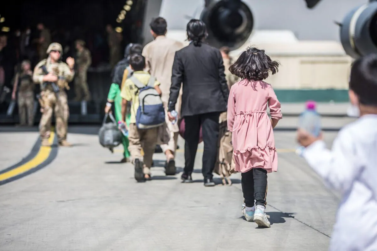 Families begin to board a U.S. Air Force C-17 Globemaster III transport plane during an evacuation at Hamid Karzai International Airport, Afghanistan, on Aug. 23, 2021. (U.S. Marine Corps/Sgt. Samuel Ruiz/Handout via Reuters)
