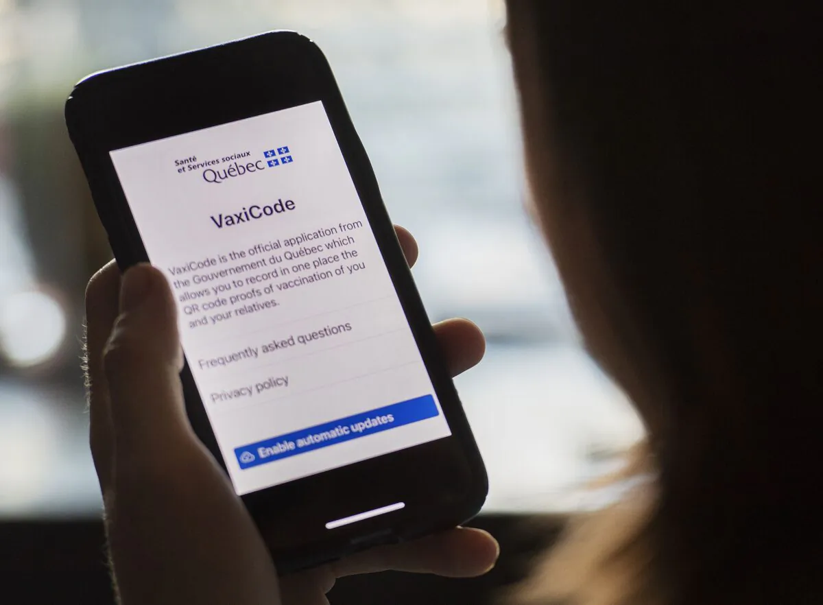 A woman looks at the Quebec government’s new vaccine passport, called VaxiCode, on a phone in Montreal on Aug. 25, 2021. (The Canadian Press/Graham Hughes)