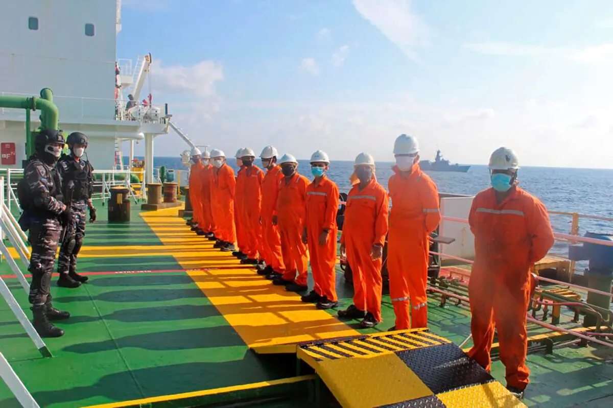 Indonesian navy personnel detain crew members of the Bahamas-flagged tanker MT Strovolos after its seizure in the waters off Riau Islands, Indonesia, on Aug. 25, 2021. (Indonesian Navy via AP)