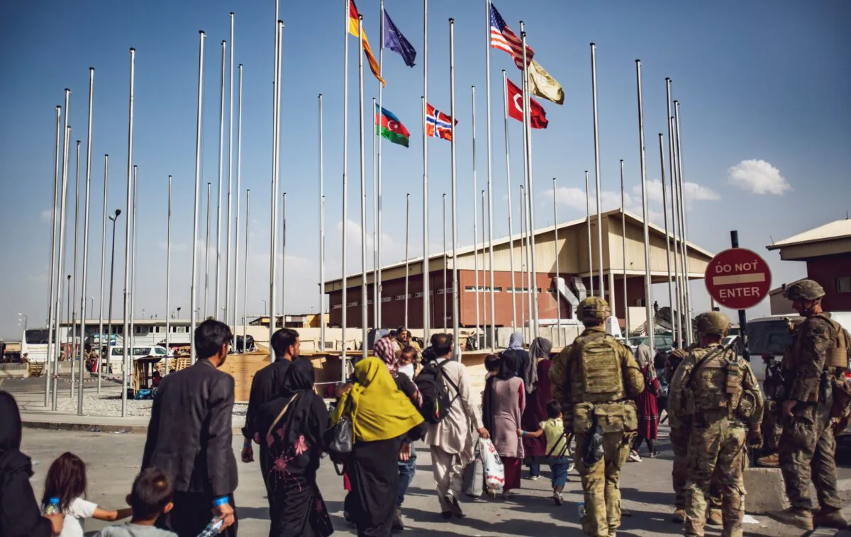 Soldiers assigned to the 82nd Airborne Division escort a group of people to the terminal at Hamid Karzai International Airport in Kabul, Afghanistan, on Aug. 23, 2021. (1st Lt. Mark Andries/U.S. Marine Corps via AP)