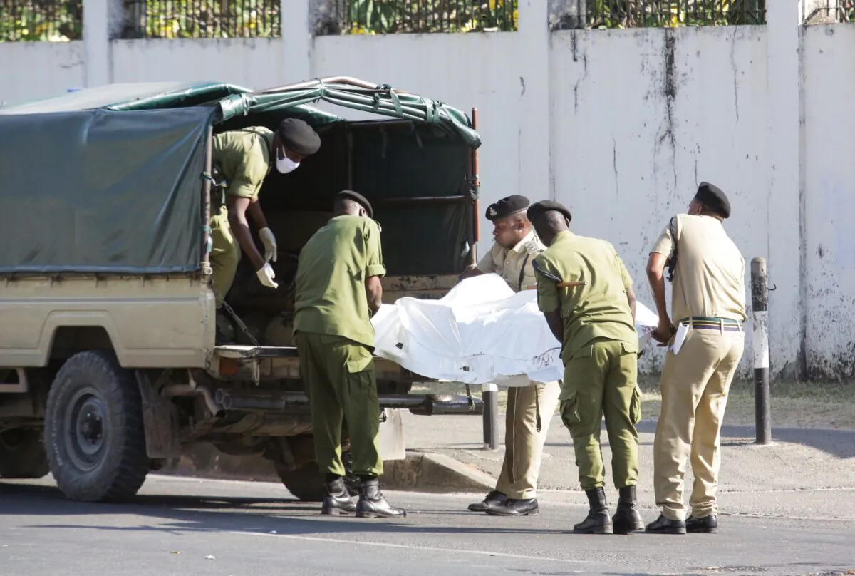 Tanzanian security forces remove the slain body of an attacker who was wielding a rifle, outside the French embassy in the Salenda area of Dar es Salaam, Tanzania, on Aug. 25, 2021. (Emmanuel Herman/Reuters)