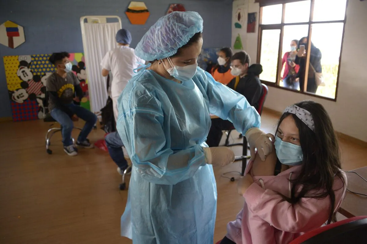 A teenager receives a dose of the Pfizer-BioNTech vaccine against COVID-19 at the Cecilia Rivadeneira Foundation in Quito, on July 21, 2021. (RODRIGO BUENDIA/AFP via Getty Images)