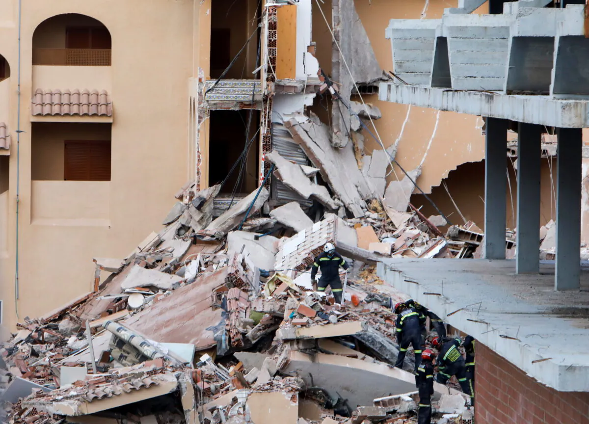 Firefighters work among the debris of a collapsed building in the town of Peniscola, Spain, on Aug. 26, 2021. (Eva Manez/Reuters)