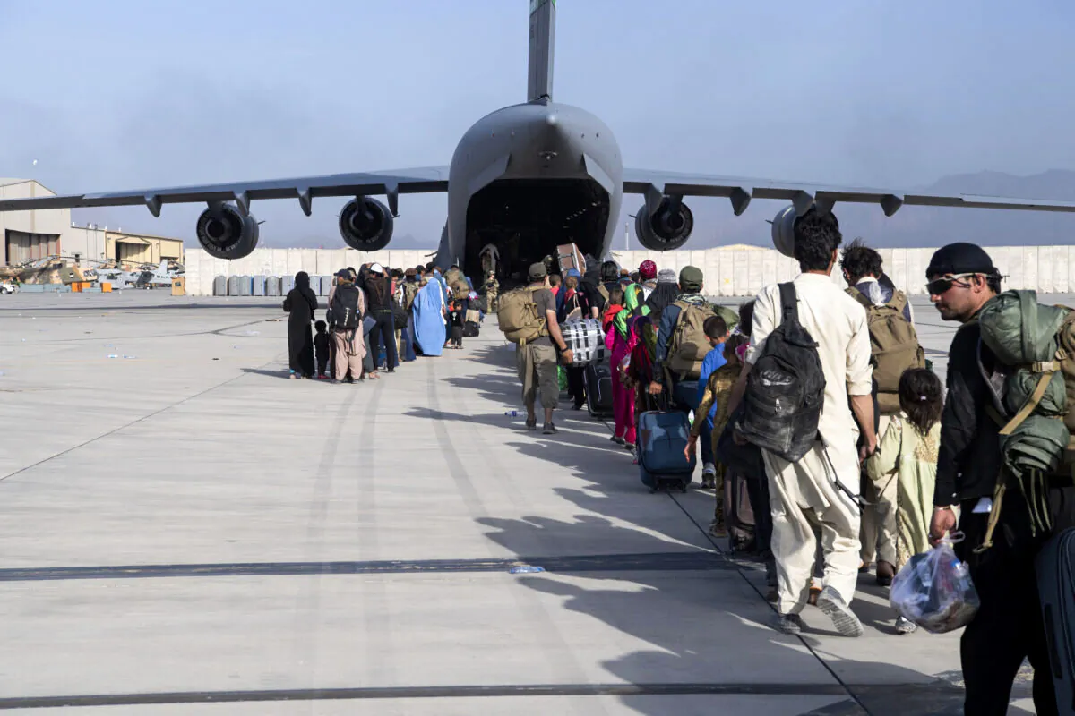 U.S. Air Force loadmasters and pilots, assigned to the 816th Expeditionary Airlift Squadron, load people being evacuated from Afghanistan onto a U.S. Air Force C-17 Globemaster III at Hamid Karzai International Airport in Kabul, Afghanistan, on Aug. 24, 2021. (Master Sgt. Donald R. Allen/U.S. Air Force via AP)