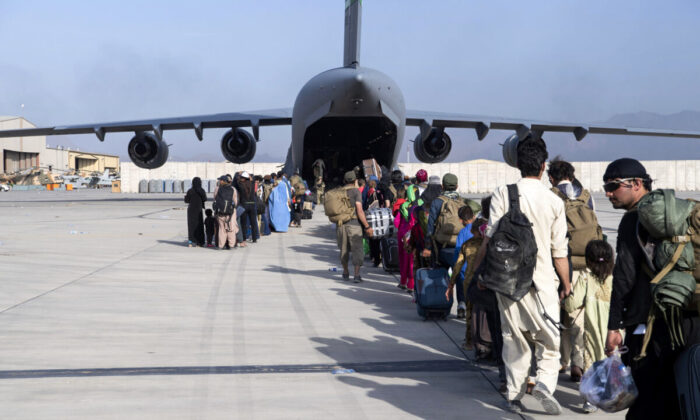 U.S. Air Force loadmasters and pilots, assigned to the 816th Expeditionary Airlift Squadron, load people being evacuated from Afghanistan onto a U.S. Air Force C-17 Globemaster III at Hamid Karzai International Airport in Kabul, Afghanistan, on Aug. 24, 2021. (Master Sgt. Donald R. Allen/U.S. Air Force via AP)