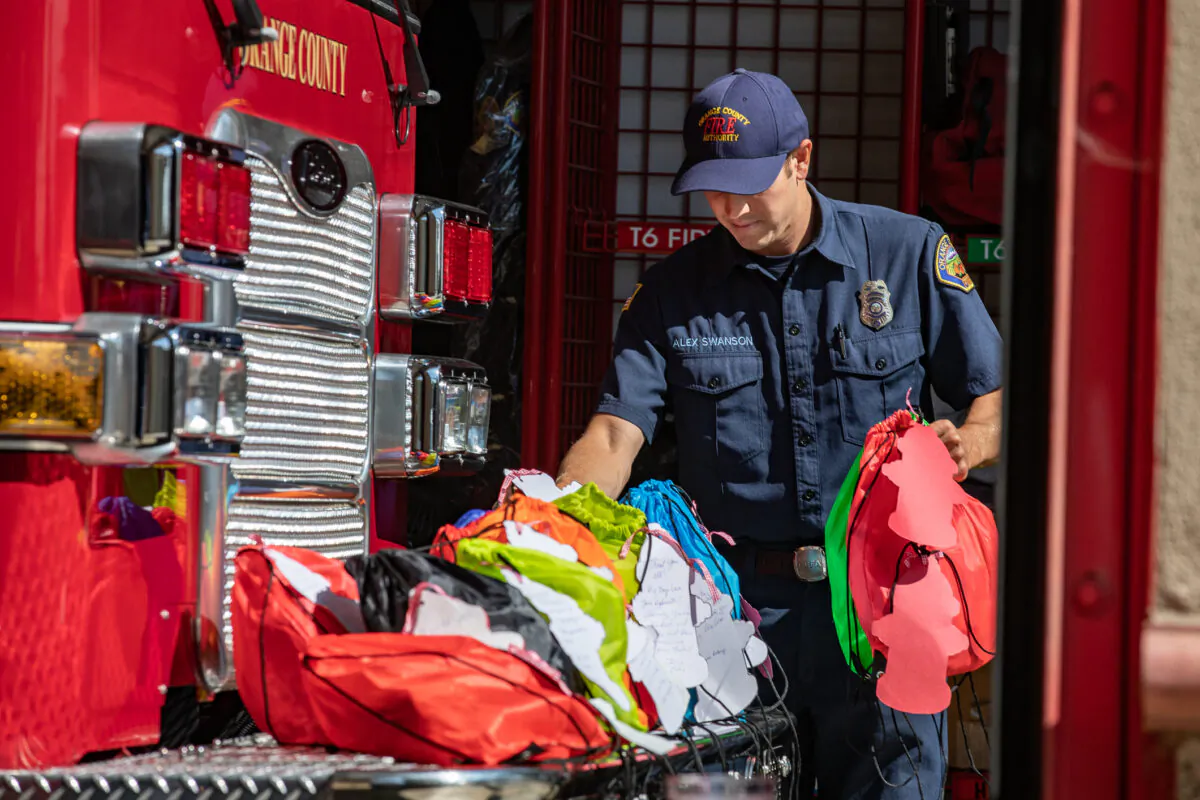 Orange County Fire Authority firefighters recieve gift bags that will be taken to OCFA members fighting statewide fires in Irvine, Calif., on Aug. 26, 2021. (John Fredricks/The Epoch Times)