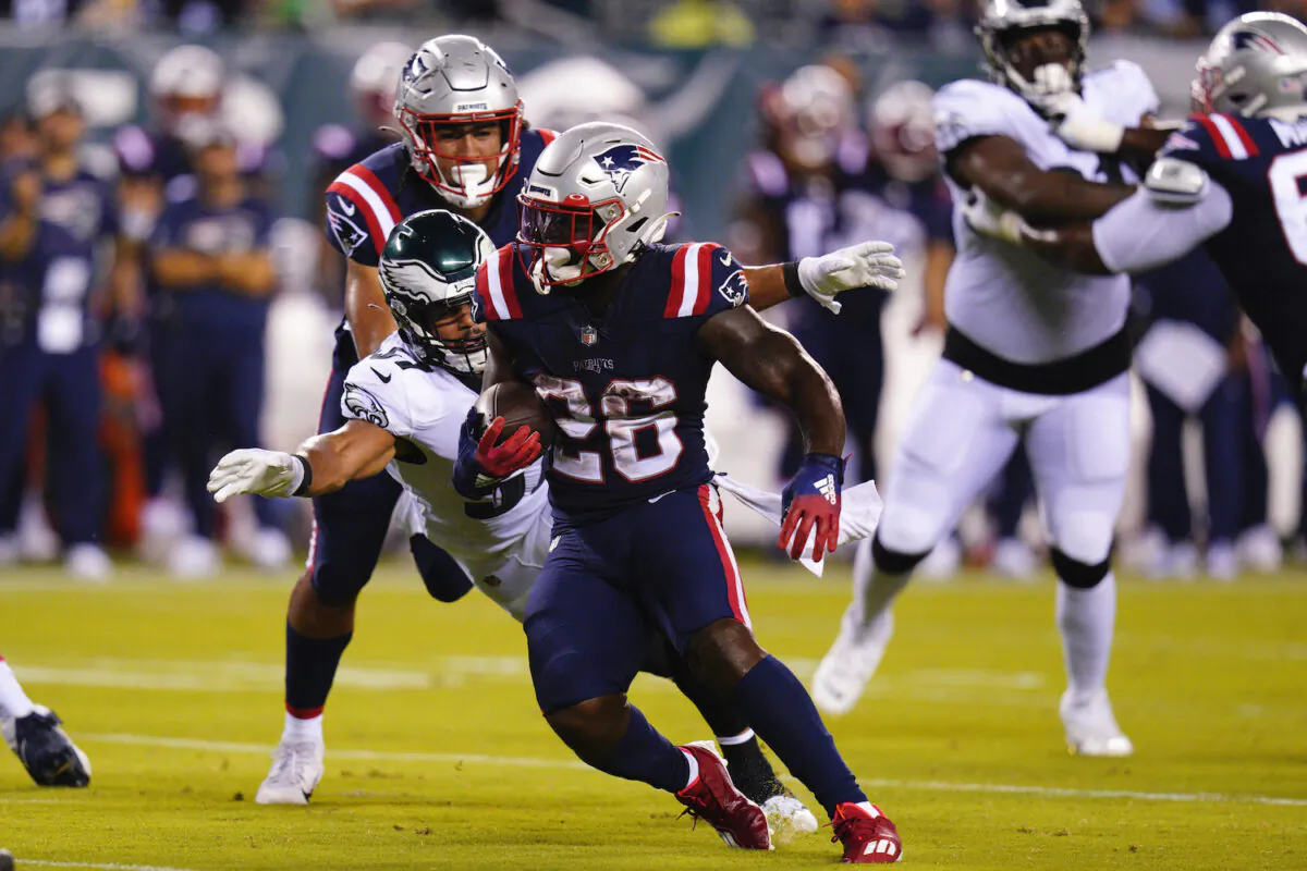 New England Patriots' Sony Michel runs with the ball as Philadelphia Eagles' T.J. Edwards tries to bring him down during the first half of a preseason NFL football game in Philadelphia on Aug. 19, 2021. (AP Photo/Chris Szagola)